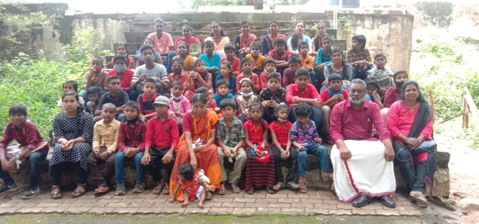 Children and adults gathered for a community photograph