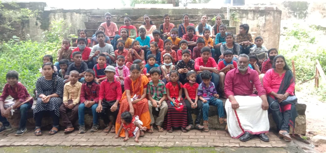 Children and adults gathered for a community photograph