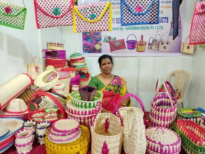 A craftsperson with a display of colourful handmade baskets
