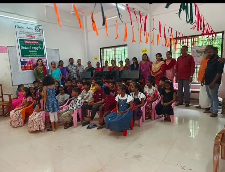 Children and adults gathered for a school-supplies programme at CADRE-India